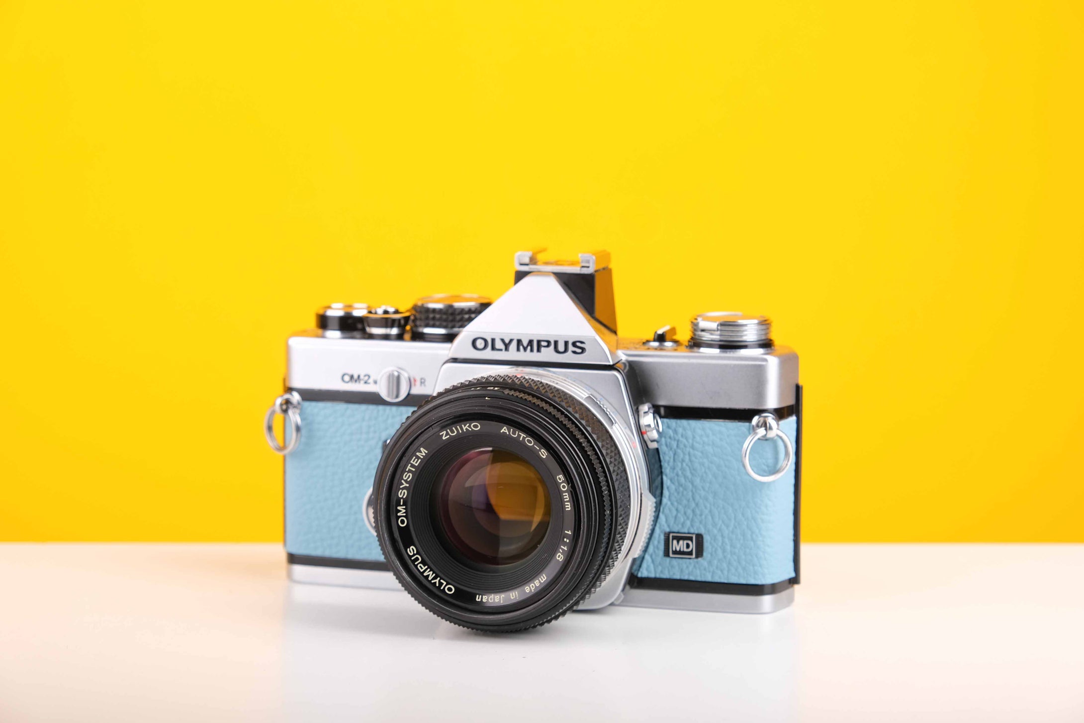 Olympus OM2n 35mm Film Camera in New Light Blue Leather Skin with Zuiko Olympus OM-System Auto-S 50mm f1.8 Lens