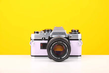 Load image into Gallery viewer, Olympus OM10 35mm SLR Film Camera with Manual Adapter and Olympus Zuiko MC Auto-S 50mm f1.8 Lens in Lilac
